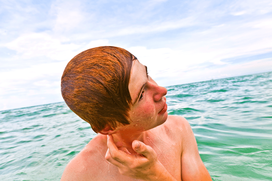 Boy with a ears blocked by water from swimming