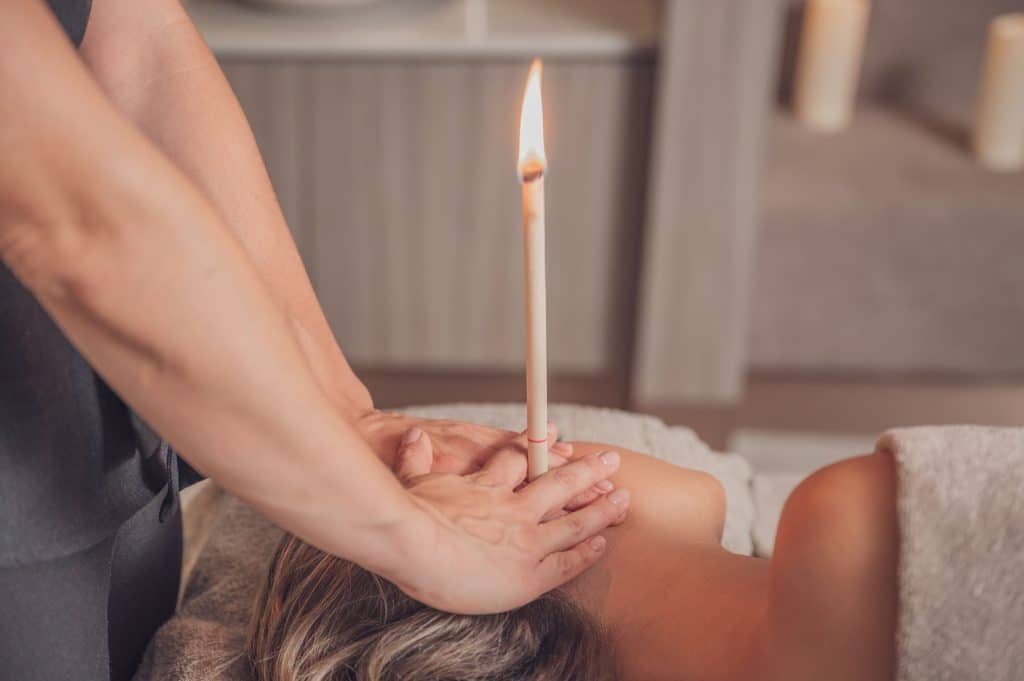 Woman receiving an ear candle treatment