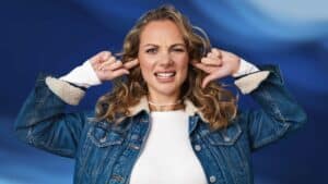 Woman plugging ears and grimacing, showing signs of ear discomfort or blocked ears