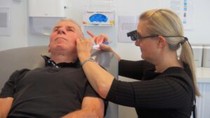 Clinician performing professional ear wax removal using microsuction technique