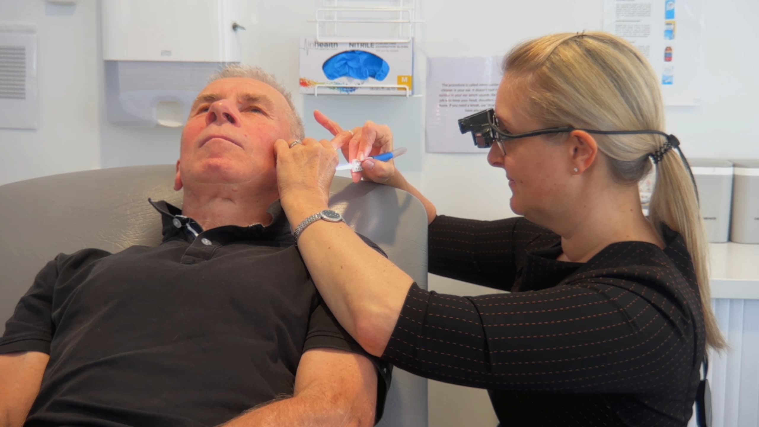 Clinician performing professional ear wax removal using microsuction technique